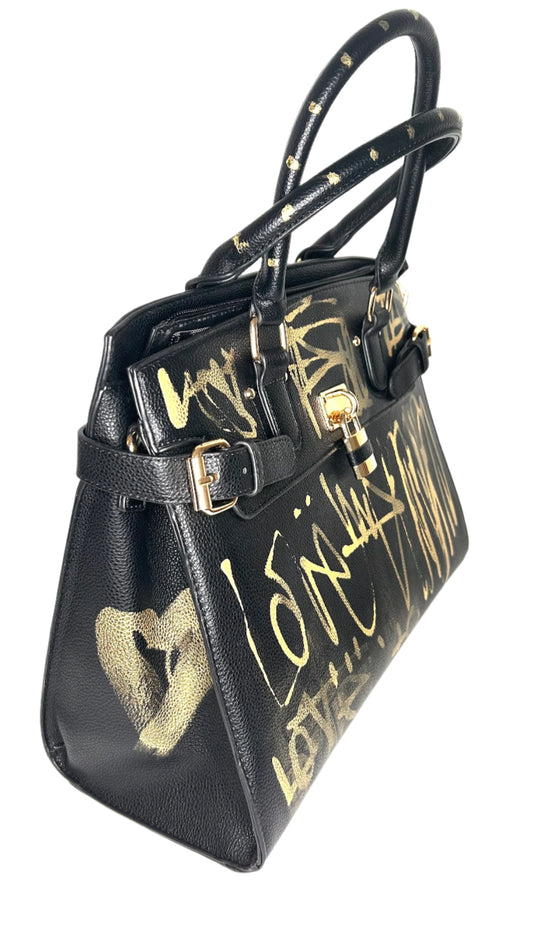 Black handbag with gold text and design on a white background