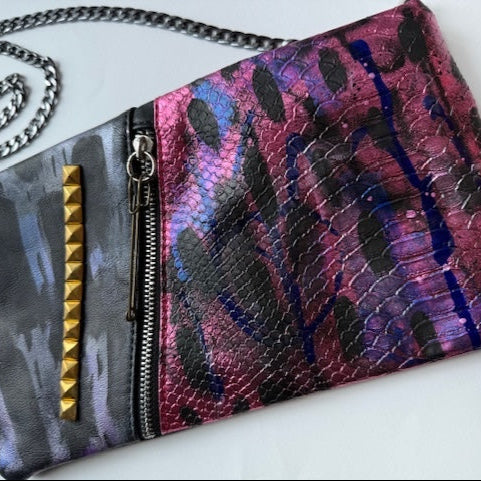 Multicolored patterned pouch with chain strap on a white background