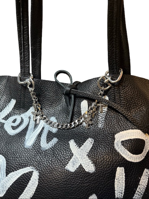 Black handbag with white text and chain details on a white background