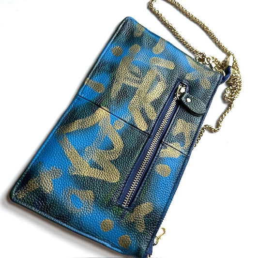 Blue handbag with gold pattern and chain strap on a white background