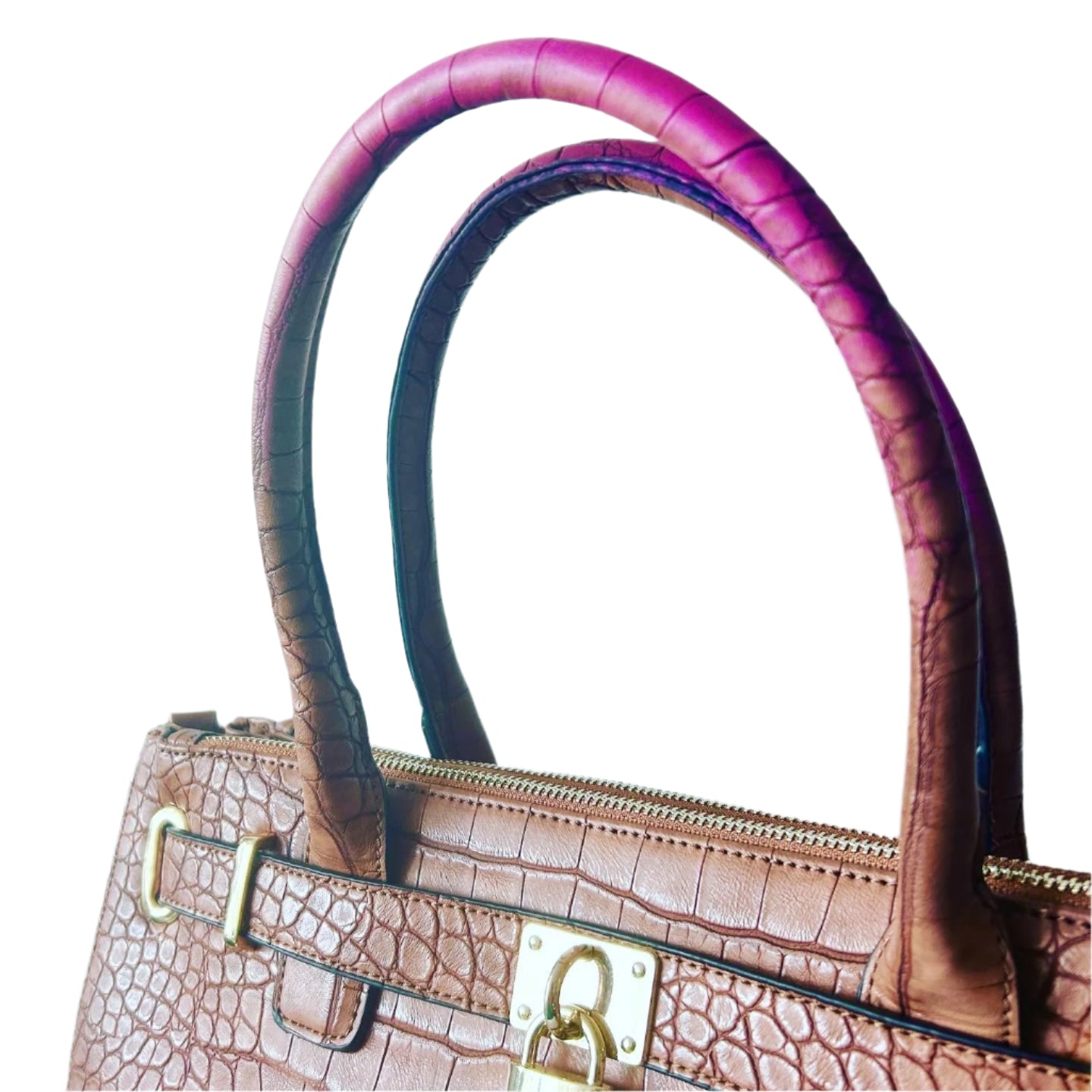 Brown crocodile-patterned handbag with pink and black handles on a light blue background