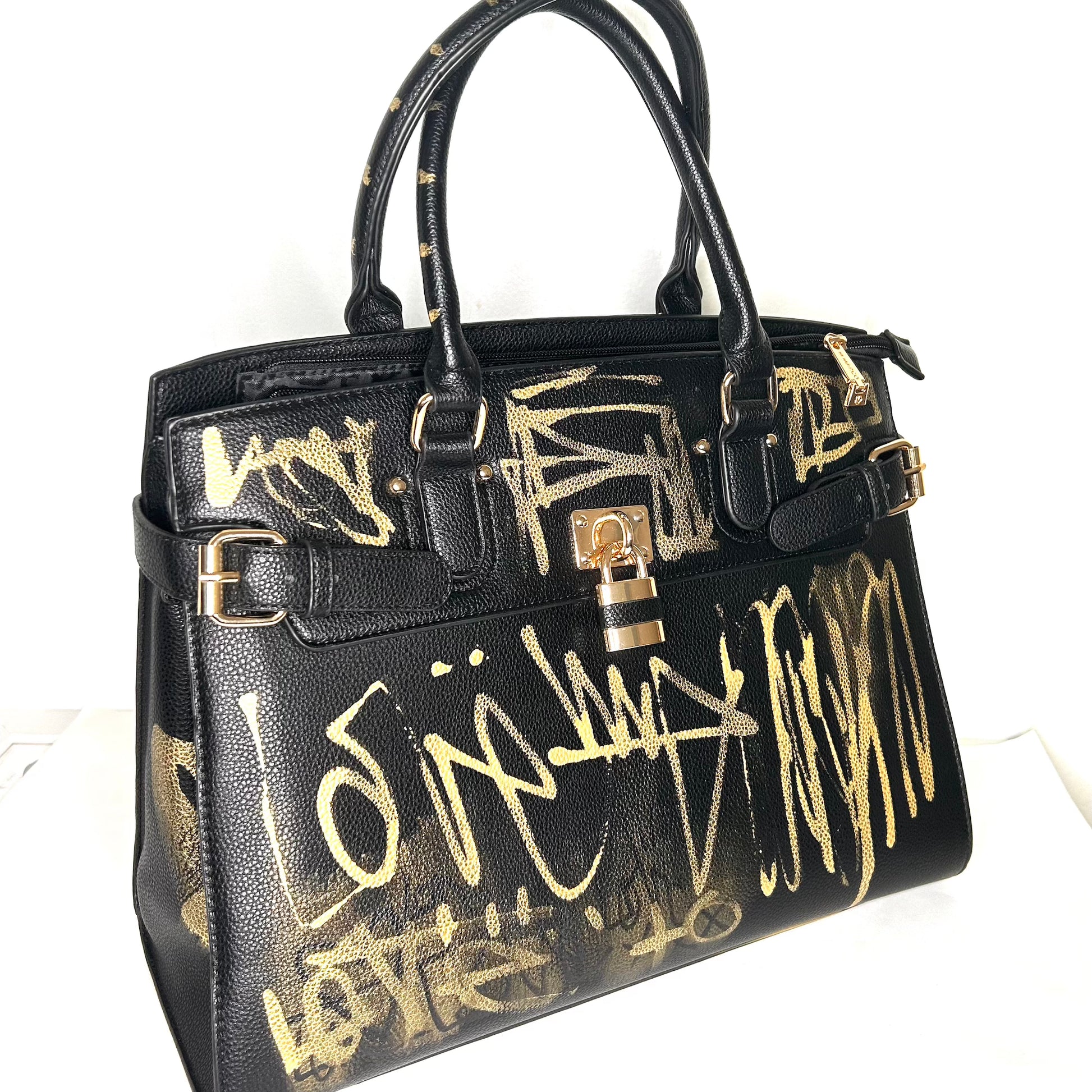 Black handbag with gold graffiti-style text on a white background