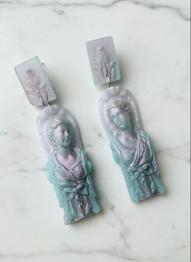 Pair of earrings with classical figure design on a marble surface
