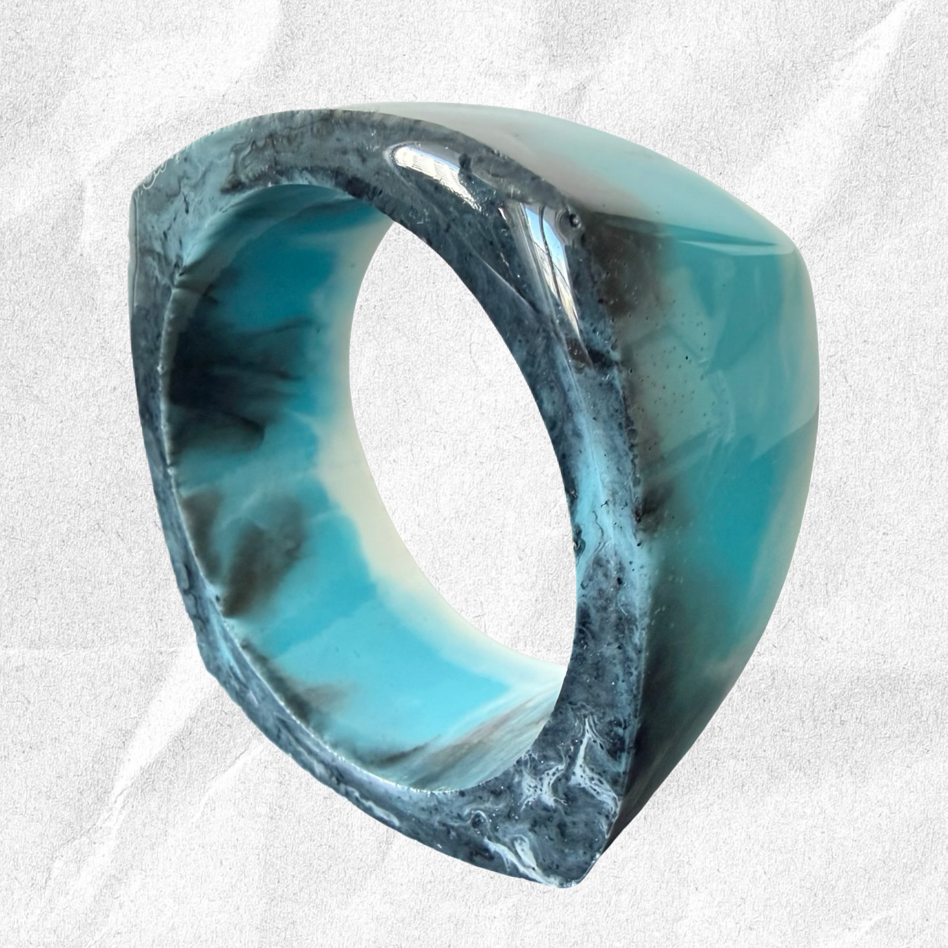 Marbled blue and gray bracelet on a textured white background