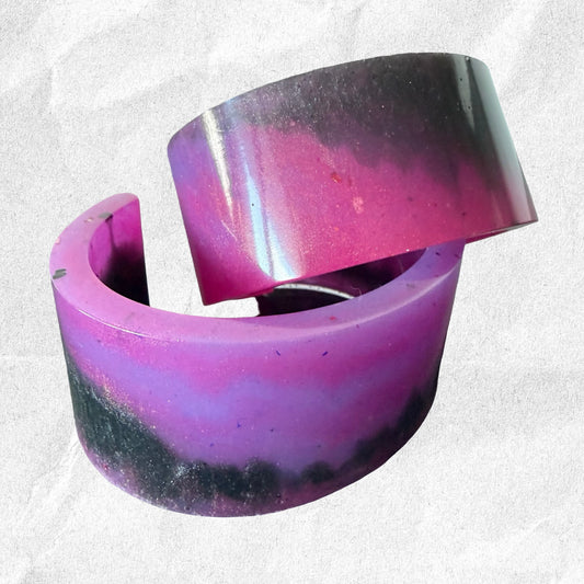 Purple and black resin ring on a textured white background