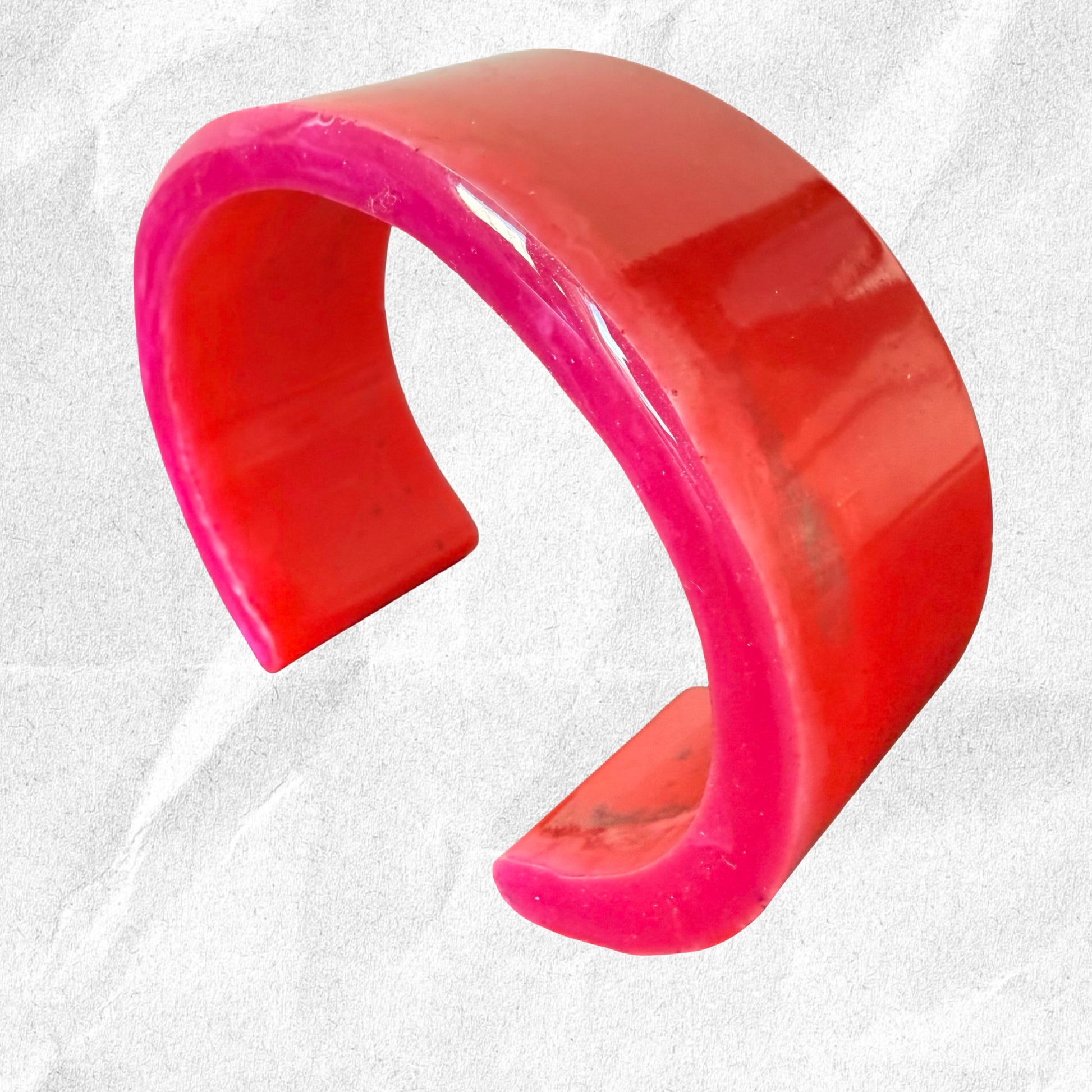 Pink and red bangle on a textured white background