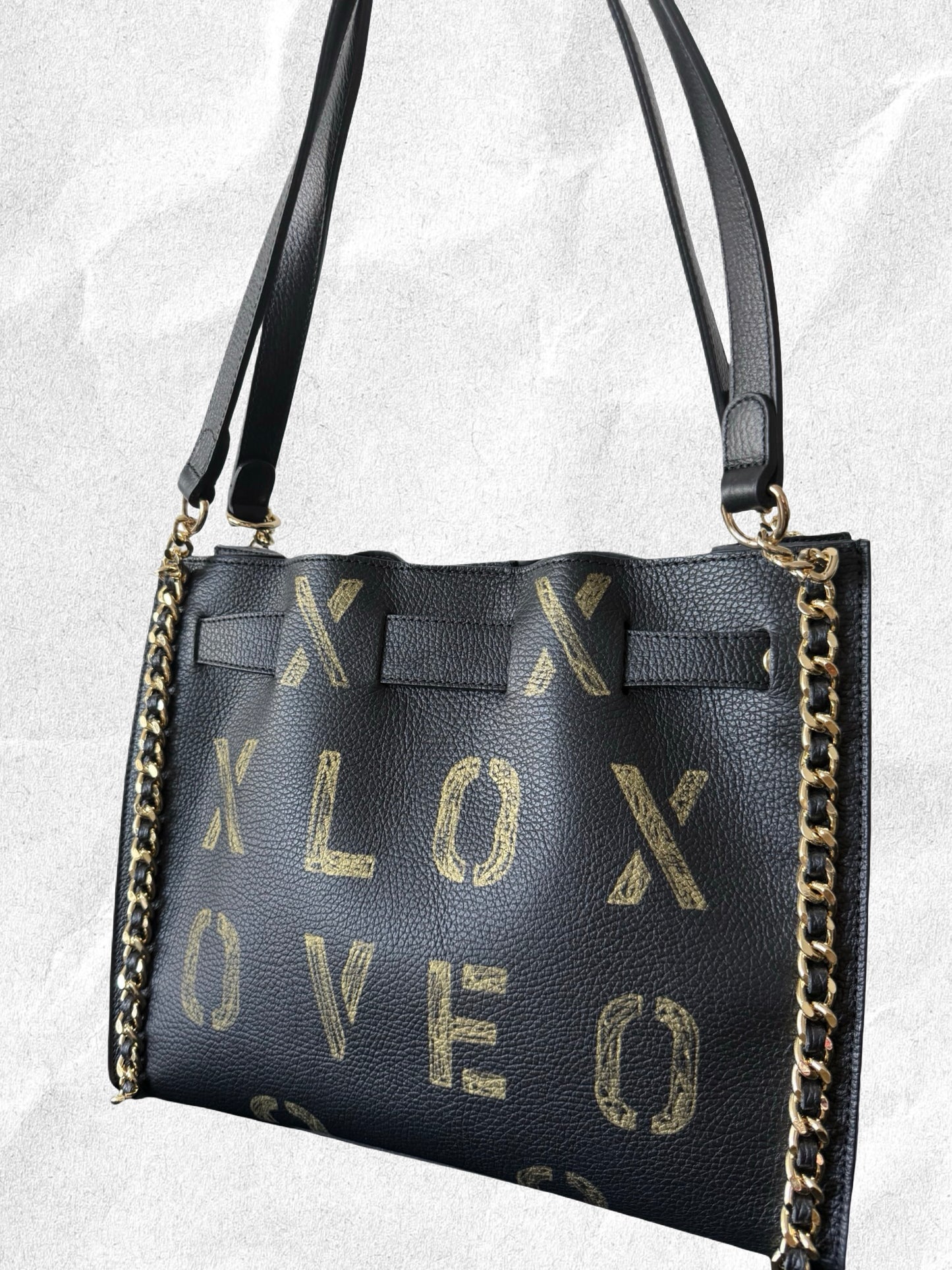 Black handbag with gold 'XOXO LOVE' text on a light gray background