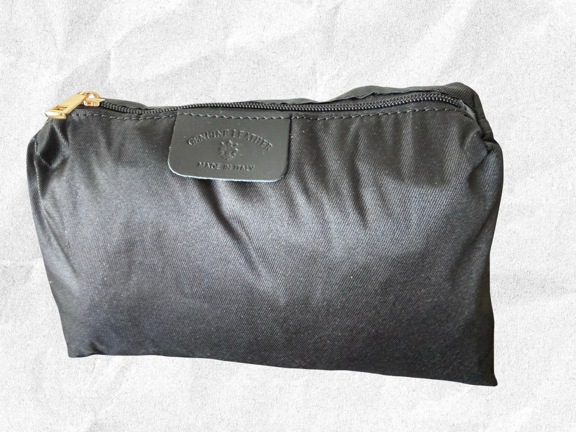 Black pouch with a brand tag on a light gray background