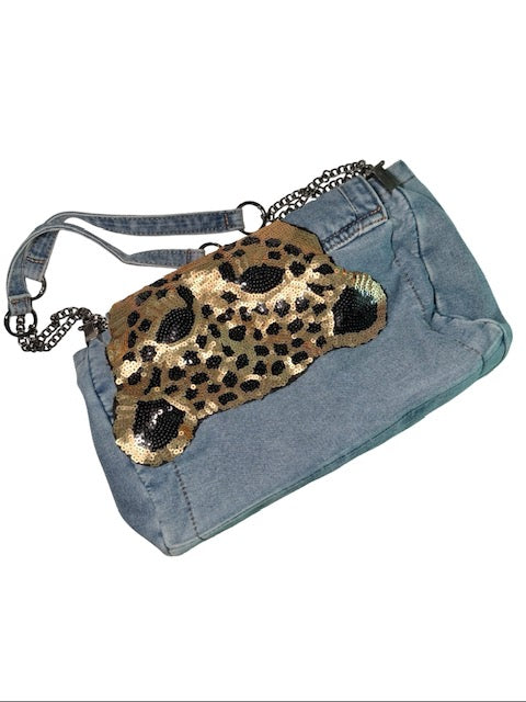 Denim bag with a leopard print clutch on a white background