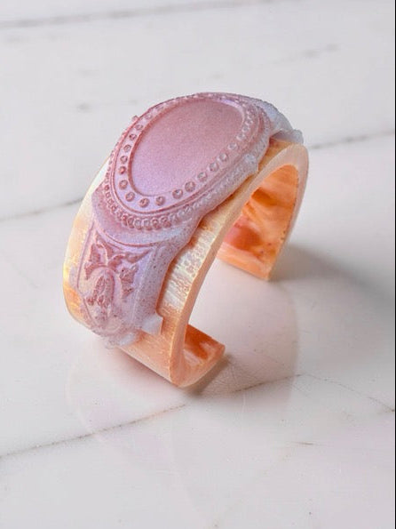 Decorative pink and orange bracelet on a marble surface