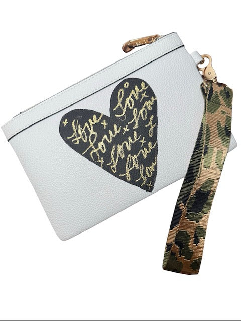 White pouch with gold heart design and camouflage strap on a white background