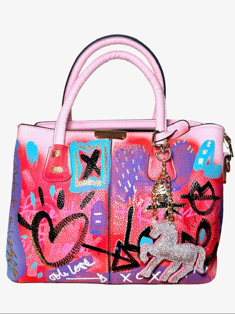 Colorful handbag with pink handle and graffiti-style design on a white background
