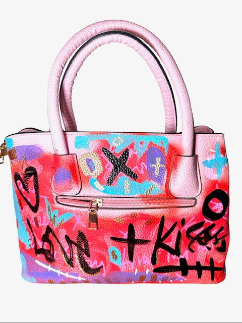 Colorful handbag with graffiti-style text and designs on a white background