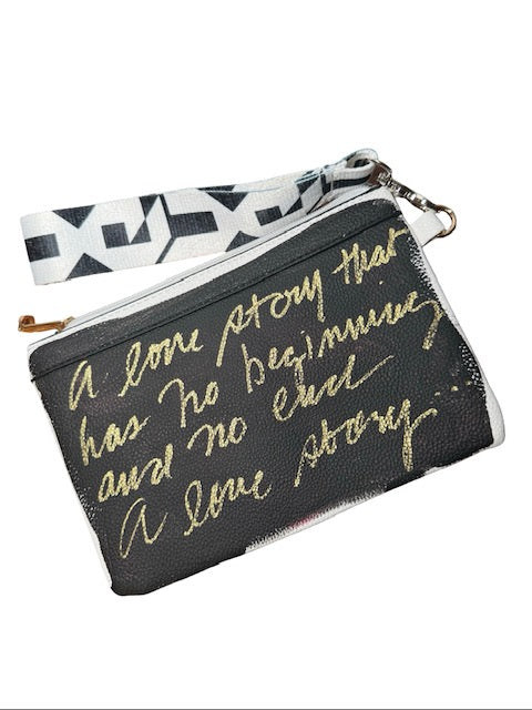 Black pouch with gold text and a white strap on a white background