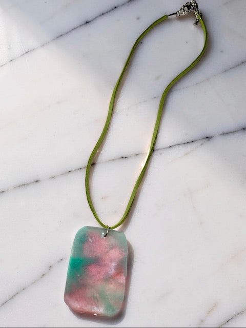 Necklace with a rectangular pendant on a marble surface