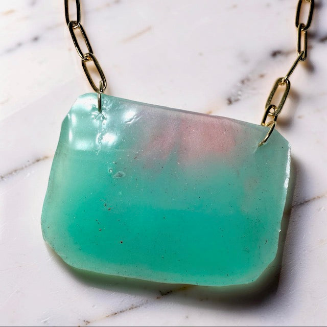 Necklace with an aqua blue pendant on a marble surface