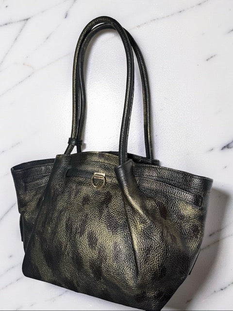 Black leather handbag on a white marble surface