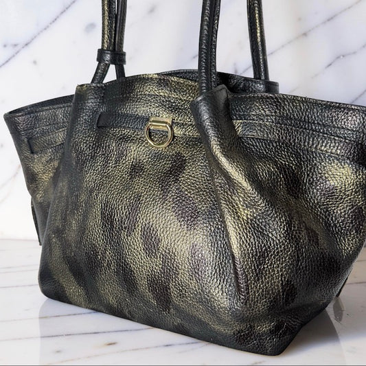 Black leather handbag with gold accents on a marble surface