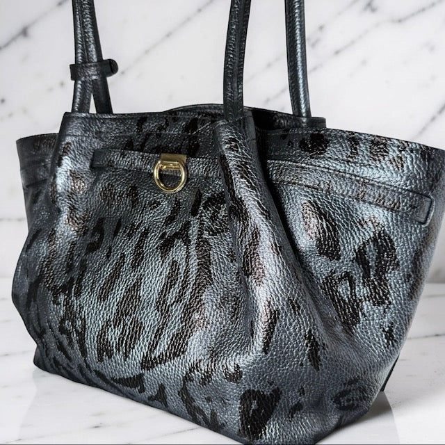Leopard print handbag with gold clasp on a marble surface