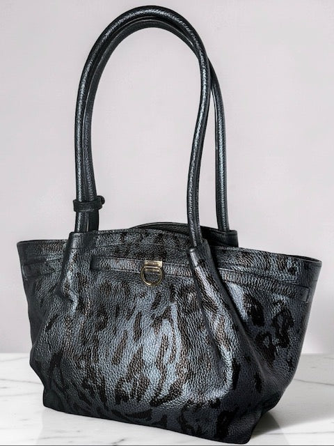 Black and gray patterned handbag on a white surface with a light gray background