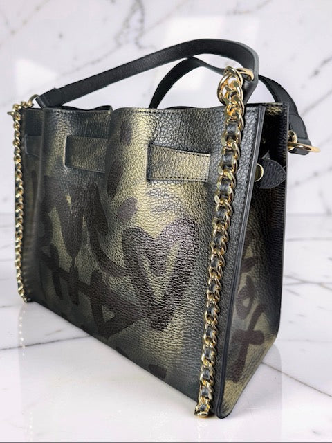 Graffiti-patterned handbag with gold chain detail on a white background
