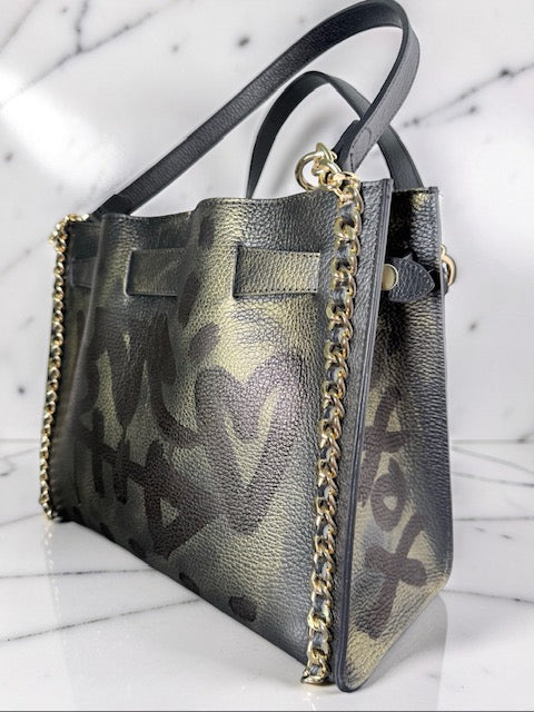 Black and gold handbag with chain detail on a marble surface