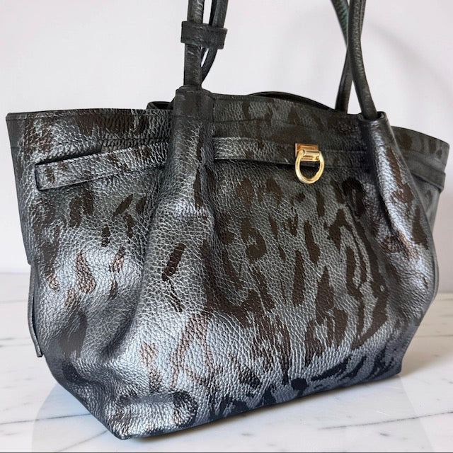 Leopard print handbag with gold clasp on a white surface