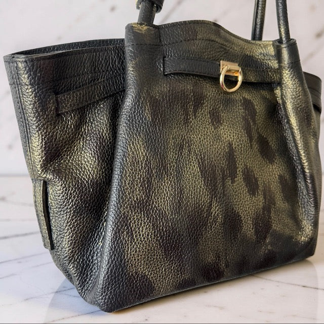 Black leather handbag with gold accents on a marble surface