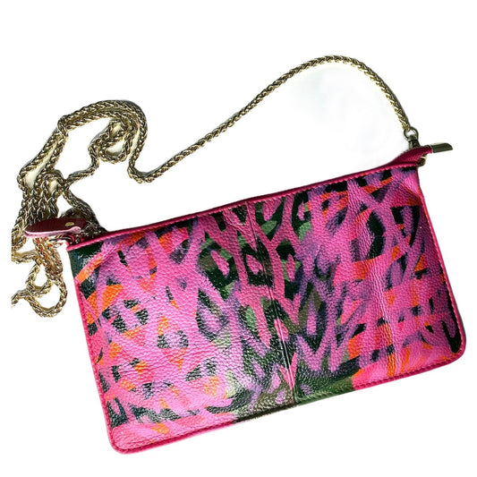 Pink clutch with colorful abstract design and gold chain strap on a white background