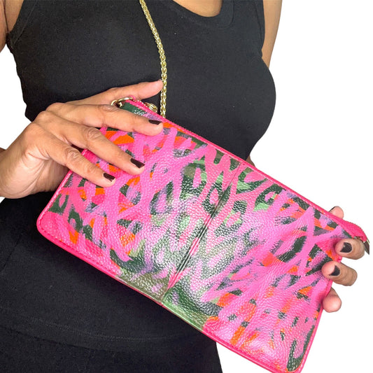 Person holding a pink clutch with floral pattern