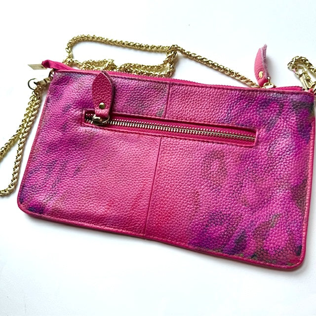 Pink handbag with gold chain strap on a white background