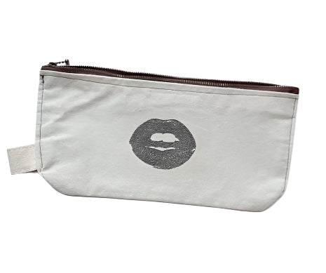 Beige pouch with a black lip print on a light gray background